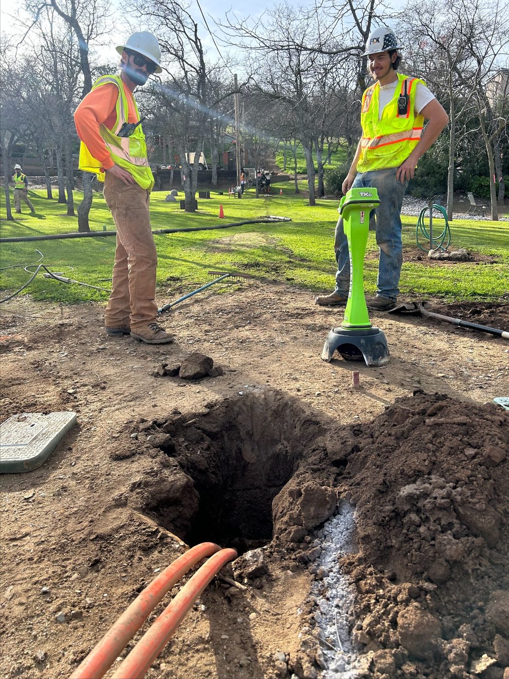 Peak Excavating crew in hi-vis vests working at a trench