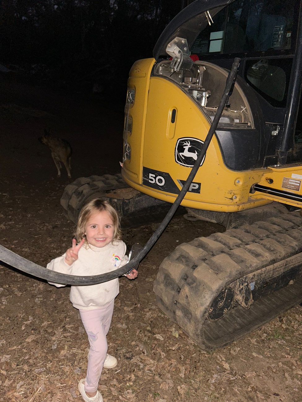 A child standing beside one of Peak Excavating's excavators